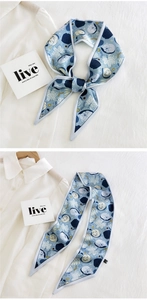 Detail of blue floral silk scarf with cute cat print tied on a white shirt collar