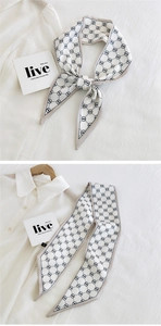 Detail of a white narrow twilly scarf with black mustache and diamond pattern
