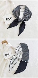Detail of a black and white houndstooth skinny scarf with Christian Mido lettering