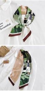 Détail d'un foulard en soie verte avec illustration et lettrage 'be as you wish'