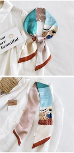 Détail d'un foulard en soie à imprimé artistique noué sur une chemise blanche