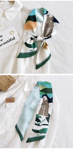 Détail d'un foulard étroit en soie à motif artistique noué sur une chemise blanche