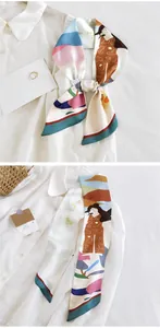 Détail d'un foulard en soie avec imprimé artistique noué sur un col de chemise blanc