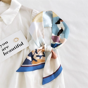 Écharpe longue en soie à motifs abstraits nouée sur une chemise en coton blanc élégante