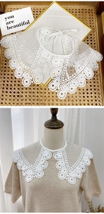 Detail of white lace detachable collar featuring hollow embroidery and tie-up design