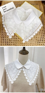 Detail of white lace fake collar featuring floral embroidery and wavy hollowed edges