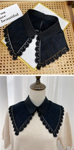 Detail of black lace embroidered decorative faux collar with intricate floral patterns