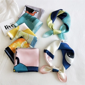Silk-like square scarves with various prints including lemon and cat patterns