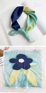 Detail of square silk scarf with blue floral prints and elegant artistic textures
