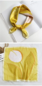 Detail of yellow silk scarf featuring large white tulip pattern and satin texture