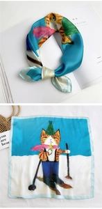 Detail of silk square scarf featuring orange skiing cat print and neat stitched edges
