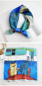 Detailed view of silk square scarf featuring a cat illustration in blue and beige tones