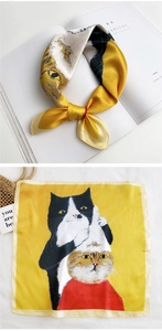 Detail of yellow silk scarf with hand-painted cat illustrations for neck or hair styling