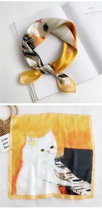 Macro view showing the smooth satin texture and hand-drawn white cat print on silk scarf