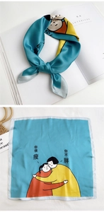 Detail of teal square silk scarf featuring artistic illustration and satin finish texture