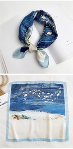 Detail of square silk scarf featuring hand-painted ocean waves and fish pattern design