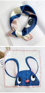 Detail of silk square scarf featuring cute blue cartoon rabbits and pink border stitching