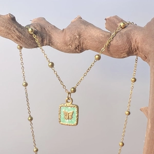 Détail d'un pendentif papillon vintage sur une chaîne à perles plaquée or élégante