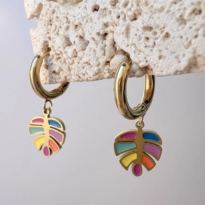 Detail der goldenen Schmetterlings-Creole mit buntem Emaille-Tropföl im Tropenblatt-Design