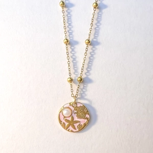Detail of 18K gold necklace featuring a pink enamel ocean pendant with sea shell and pearl