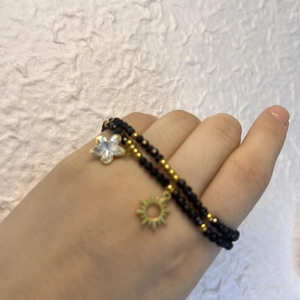 Double-layered black glass bead bracelet with gold sun and star charms for daily wear