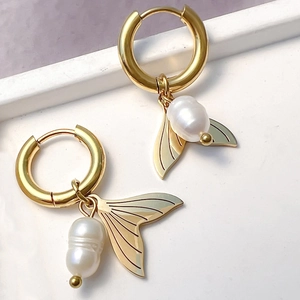 Chic gold hoop earrings featuring elegant fishtail charms and white baroque pearl drops
