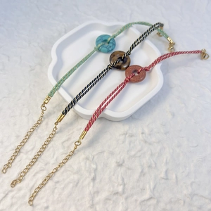 Handmade woven natural stone bracelets with Tiger Eye and Aventurine on ceramic tray