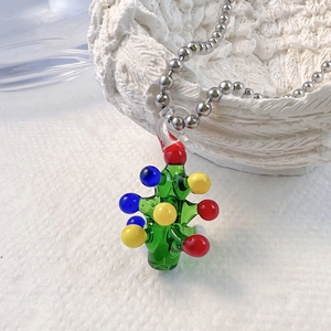 Gros plan d'un pendentif arbre de Noël en verre fait main avec des perles colorées