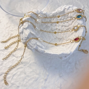Set aus vier vergoldeten Edelstahl-Armbändern mit farbigen Wassertropfen-Steinen und Perlen
