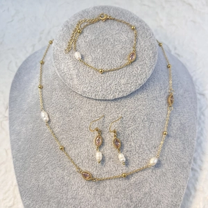 Set dettagliato di collana, bracciale e orecchini in oro con zirconi e perle