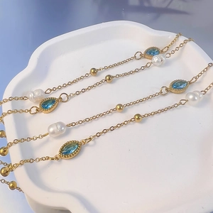 Collana vintage francese dorata con perle barocche e pietre blu su vassoio bianco