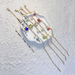 Ensemble de bracelets dorés multicouches avec étoiles colorées et perles sur plateau blanc