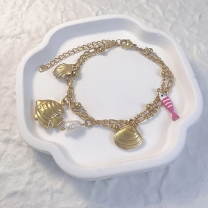 Détail du bracelet multicouche en acier inoxydable doré avec étoiles de mer et perle