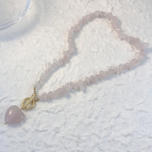 Collier en pierres roses concassées avec pendentif cœur et fermoir en T doré brillant
