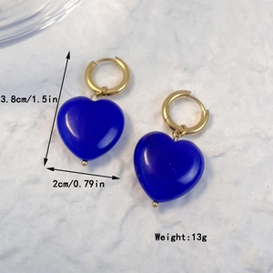 Orecchini a cuore con pietra blu scuro e cerchi dorati su sfondo bianco strutturato