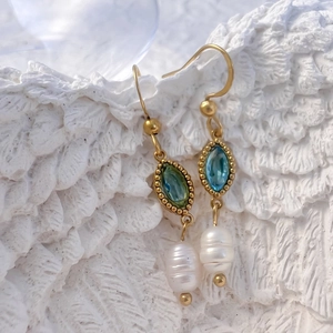 Vue détaillée de boucles d'oreilles en acier avec zircons colorés et perles d'eau douce