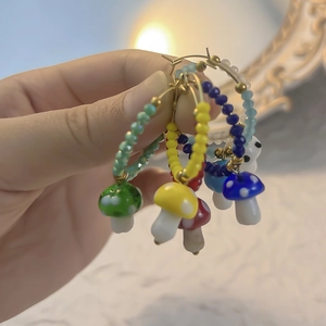 Handmade mushroom hoop earrings set with colorful polka dot glass charms and gold rings