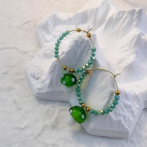 Charming gold hoop earrings with green glass beads and white spotted mushroom charms