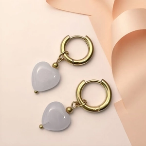 Close-up of heart-shaped natural stone earrings with gold stainless steel hoops