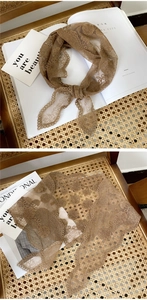 Detail of brown floral lace triangle scarf with intricate hollow embroidery and wavy edges