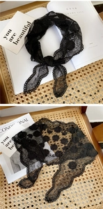 Close-up of black floral lace triangle scarf with delicate embroidery and scalloped edges