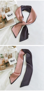 Detailed view of pink and dark taupe dual-color satin ribbon scarf on white shirt