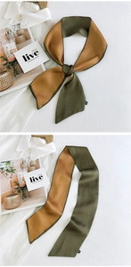 Close-up of olive green and mustard yellow long silk scarf with satin finish on white fabric