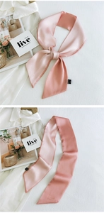 Detail of elegant pink satin skinny scarf with bias cut ends on aesthetic background