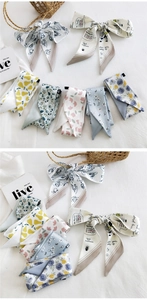 Detail of silk skinny scarves with floral prints and hand-drawn patterns for bag decoration