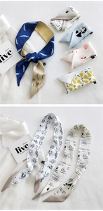 Close-up of assorted patterned silk scarves featuring crane and artistic hand-drawn prints