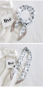 Macro view of silky twilly scarf with abstract face print and beige color-block borders