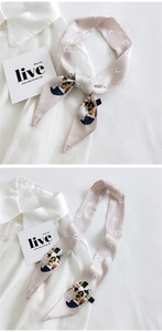 Detail of pink silk ribbon scarf with floral print and vintage illustration style