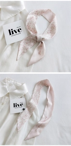 Close-up of pink floral skinny scarf twilly on white shirt showing silk texture