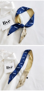 Detail of silk skinny scarf featuring double-sided crane pattern and champagne gold finish